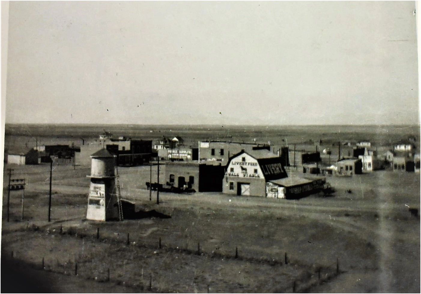 A view across rooftops towards the centre of a small town on flat land.