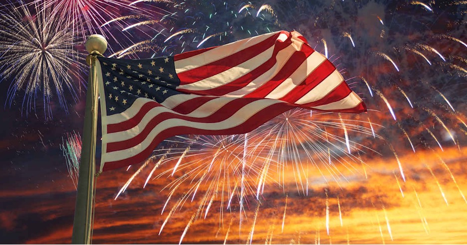 Stock image of Flag Flying with Fireworks Behind It